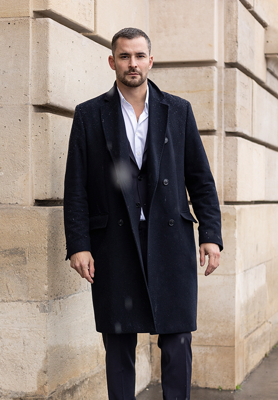 Man in a black coat and suit in a winter city outside