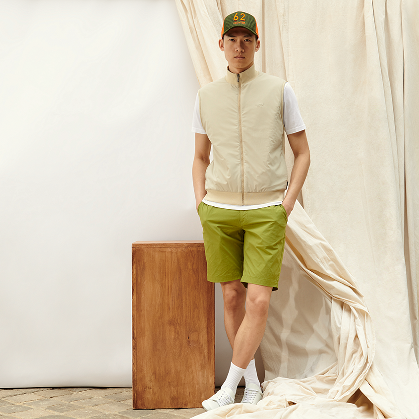 Funktionale Mode Outfit aus grünen Shorts, beiger Weste und weißem T-Shirt