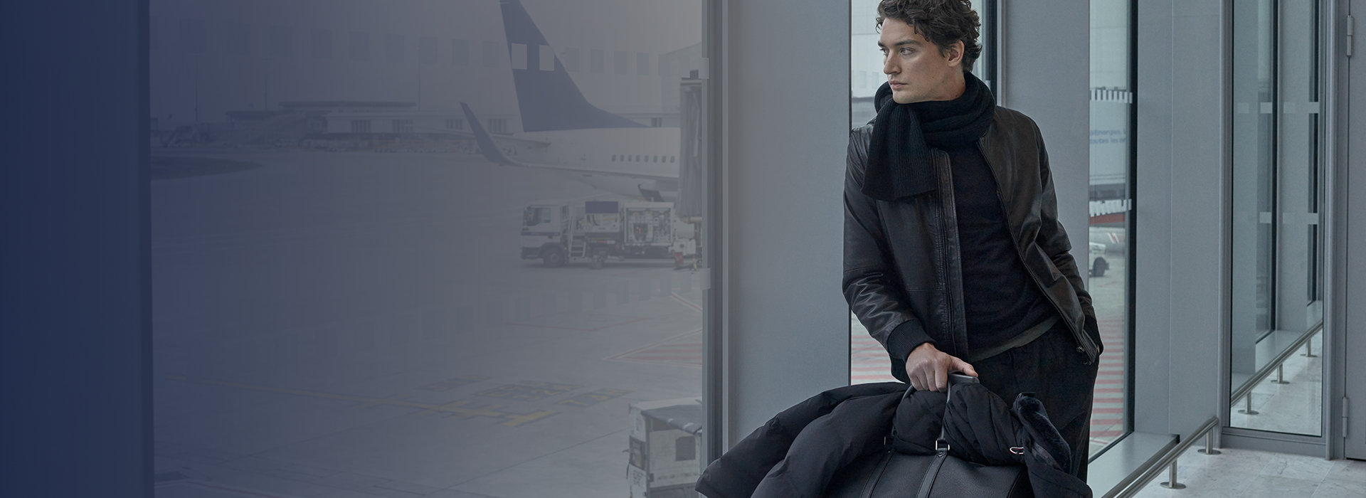 Mann am Flughafen, schaut aus dem Fenster