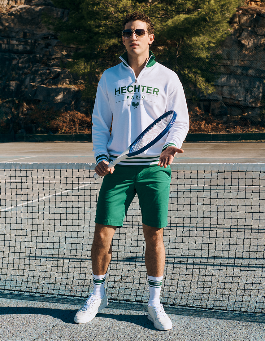 Mann in Hechter Paris Tennis Look auf Tennisplatz