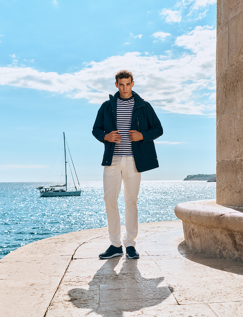 Le style marin Homme en pantalon clair, t-shirt rayé et coupe-vent bleu